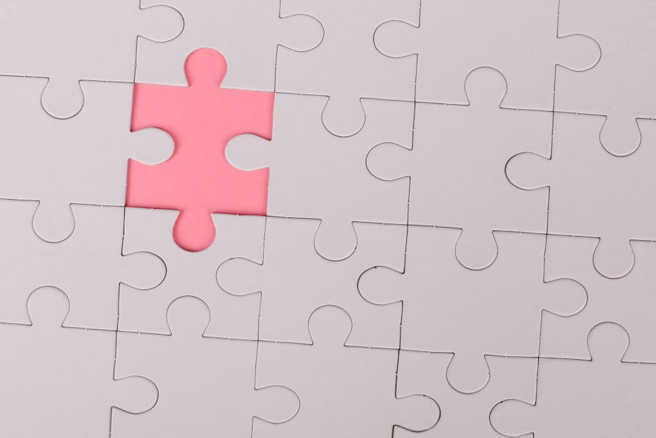 Close-up of an unfinished puzzle with a pink missing piece, highlighting emptiness.